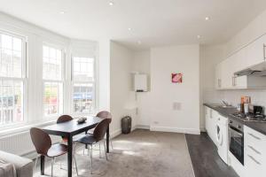 a kitchen with a table and chairs in a room at Kennington Apartment A/Apartment in London