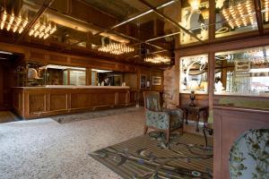 a lobby with a chair and a person in a mirror at Crest Hotel in Prince Rupert
