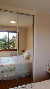 1 dormitorio con cama y espejo en Apartamento Flat, en Gramado