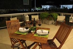 a wooden table with two chairs and wine glasses at Apartamento Playas Carilo in Carilo