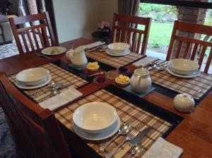 a dining room table with plates and utensils on it at Havenlee Homestay in Westport