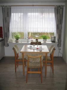 ノルデンにあるFerienwohnung Haus Antjeの窓付きのキッチン(テーブル、椅子付)