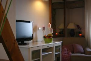 a living room with a tv and a bowl of fruit at Casa rural La Casona del Piquero in Lastres