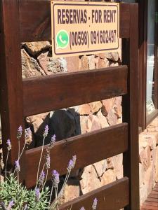 ein Schild an einem Holztor mit Blumen vor einem Gebäude in der Unterkunft Esteños de la Pedrera Posada y Spa in La Pedrera
