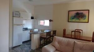 a living room with a couch and a kitchen at Condominio Arituba Tropical in Nísia Floresta