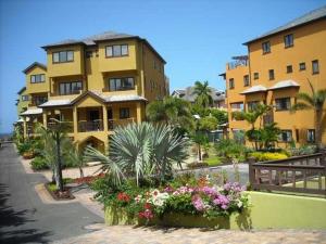 a large yellow building with flowers in front of it at Alexanders Penthouse on the beach in Ocho Rios
