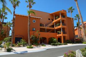 a building with palm trees in front of it at Condominios Ballena in Cabo San Lucas