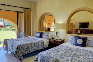 a hotel room with two beds and a window at Condominios Ballena in Cabo San Lucas +14 photos