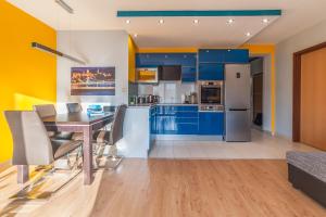 uma cozinha com armários azuis e uma mesa e cadeiras em Budapest Minimal Style - You will love it! em Budapeste