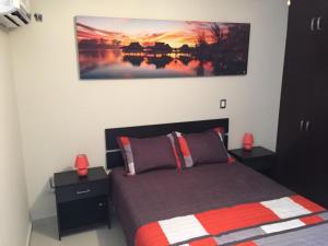 a bedroom with a bed and a painting on the wall at EV Marinos in Mazatlán