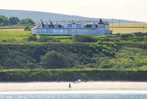 カレンにあるCullen Bay Hotelの海辺の上に座る大家