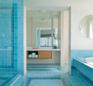 a bathroom with blue tiles and a sink and a mirror at Beverly Laurel Hotel in Los Angeles