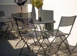 a group of chairs and a table with a vase at Bellano Motel Suites in Christchurch