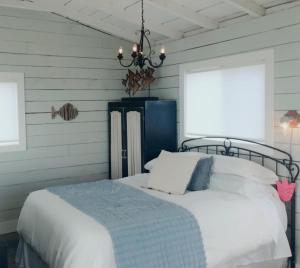 1 dormitorio con cama y lámpara de araña en BlueFin Cottage, en Indian Harbour