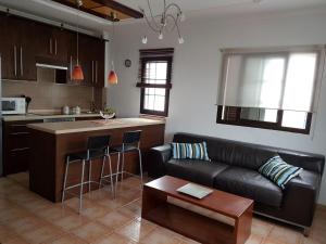 a living room with a black couch and a kitchen at Casa Garita Beach in Arrieta