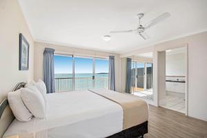 a hotel room with a large bed and a large window at BreakFree Great Sandy Straits in Hervey Bay