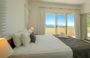 una camera da letto con un letto grande con una grande finestra di Toscana Village Resort ad Airlie Beach