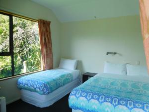 1 dormitorio con 2 camas y ventana en Mountainview Makarora Accommodation, en Makarora