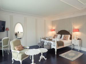 a bedroom with a bed and a chair and a table at Hôtel Mercure Villeneuve sur Lot Moulin de Madame in Villeneuve-sur-Lot +52 photos