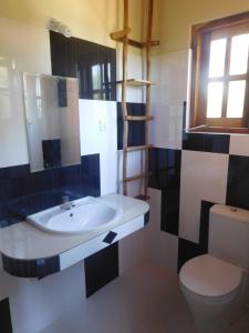 Light House Beach Hut في Komari: حمام مع حوض ومرحاض