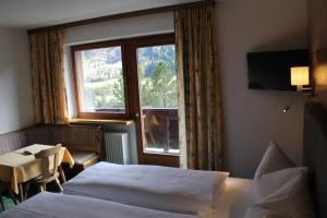 ザンクト・アントン・アム・アールベルクにあるPension Jägerhofのベッド2台と窓が備わるホテルルームです。