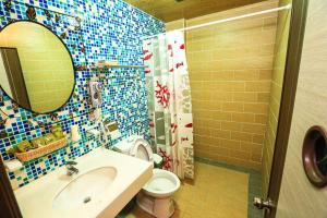 bagno con servizi igienici, lavandino e specchio di Just Coffee Hostel 2 a Beigan