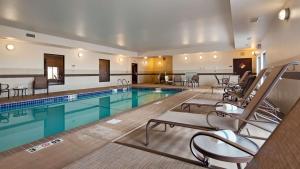 a large swimming pool with chairs in a hotel room at Best Western PLUS Casper Inn & Suites in Casper