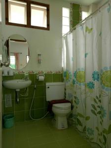 a bathroom with a toilet and a sink and a mirror at 2N Guesthouse in Phetchaburi