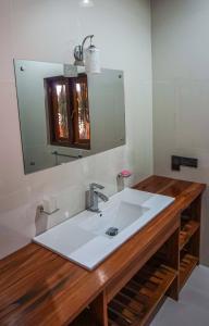a bathroom with a white sink and a mirror at Twin Waters Resort in Chilaw