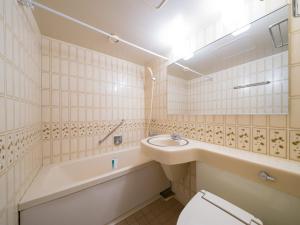 a bathroom with a sink and a tub and a toilet at APA Hotel Matsuyamajo-Nishi in Matsuyama