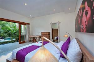 a bedroom with a bed and a swimming pool at Rumah Indah Villa in Seminyak