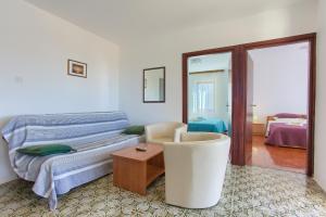 a bedroom with a bed and a chair and a table at Apartments Vlatko in Krk