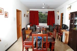 a dining room and living room with a table and chairs at Red Arrow Residency, Kolkata in Kolkata
