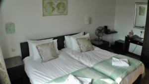 a bedroom with a bed with white sheets and pillows at Bay Lodge in Birchington