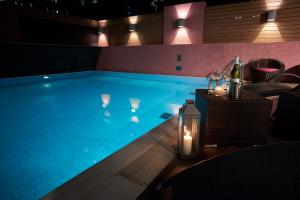 a swimming pool with a table with candles and a bottle of wine at Wharney Hotel in Hong Kong
