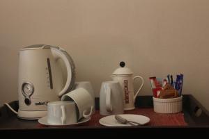 a counter with a coffee maker and cups on it at Fairways Hotel in Ballito