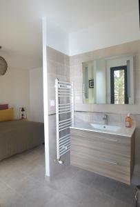 een badkamer met een wastafel, een spiegel en een bed bij Maison Canopée in Saint-Genis-les-Ollières