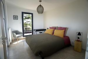 1 dormitorio con 1 cama con almohadas amarillas y rosas en Maison Canopée, en Saint-Genis-les-Ollières