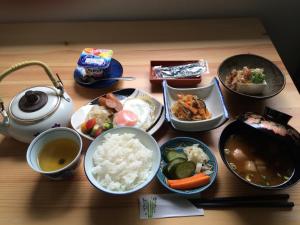 a table topped with bowls of food on a table at Ryokan Mikasaya in Beppu