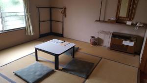 pokój ze stołem na środku pokoju w obiekcie Ryokan Mikasaya w mieście Beppu