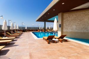 una piscina de hotel con tumbonas y sombrillas en SKY Business Hotel en Antalya