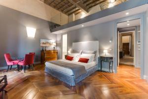 - une chambre avec un lit, une table et des chaises dans l'établissement Palazzo Del Carretto-Art Apartments and Guesthouse, à Turin