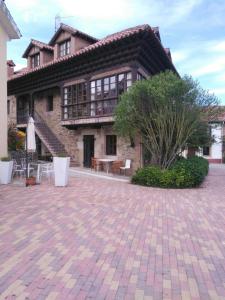 a house with a brick patio in front of it at Posada La Casona De Ucieda in Ucieda de Arriba