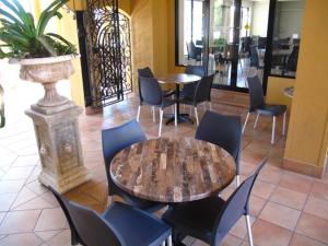 un restaurante con mesas, sillas y una planta en Palm Royale Cairns en Cairns