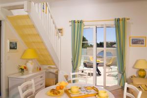 une cuisine et une salle à manger avec une table et un balcon dans l'établissement Madame Vacances Les Maisons du Lac, à Saint-Jean-de-Monts