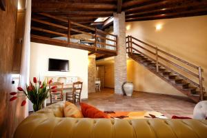 a living room with a couch and a staircase at Agriturismo Creta Rossa in Torre di Ruggiero