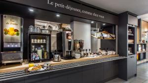 a restaurant with a counter with a coffee shop at B&B HOTEL Agen in Agen