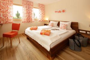 um quarto com uma cama grande e uma cadeira vermelha em BIO Hotel Bayerischer Wirt Augsburg em Augsburg