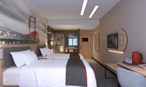 a hotel room with a large white bed and a desk at Thank Inn Chain Hotel Guangdong Zhuhai Doumen District Jing'an Bridge in Towmoon