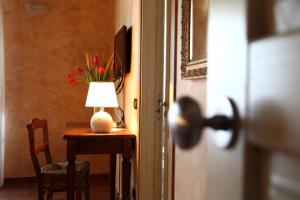 una mesa con una lámpara y un jarrón con flores. en Agriturismo Creta Rossa, en Torre di Ruggiero